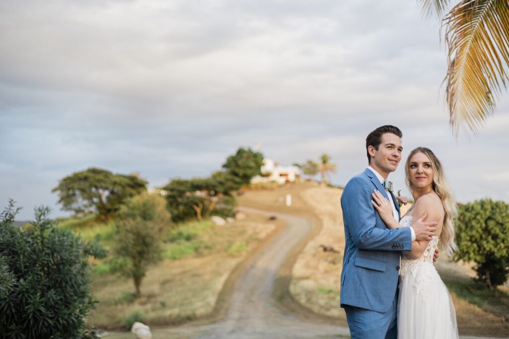 Wedding couple standing in front of El Cerro's "Rock House" in Vieques, Puerto Rico